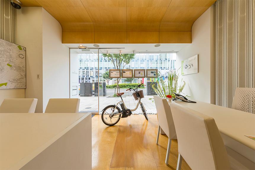 Green Seed 青山店の店内。白い椅子とテーブル、自転車が配置されたシンプルで清潔感のある空間